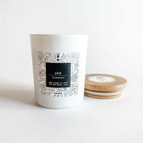 Soy wax candle in white glass jar with white washi label with black wavy line drawing with bamboo lid 